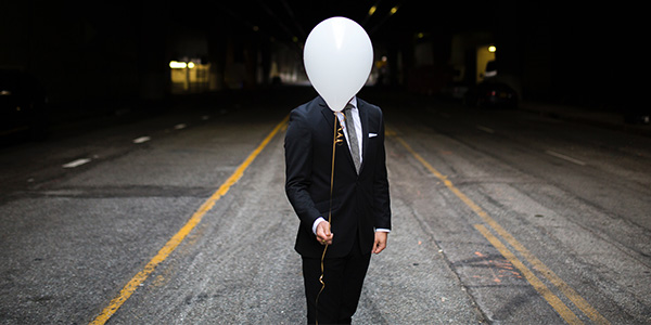 Man with ballon covering head
